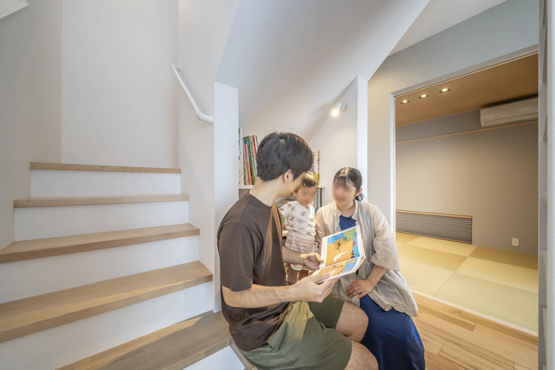 階段のそばで絵本を読む家族